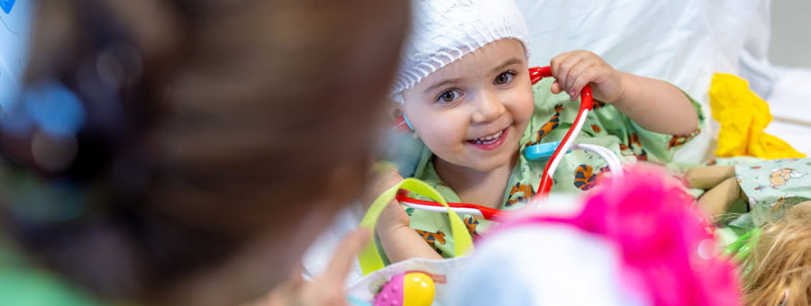 Girl listening to stethoscope. Photo by Chris Van Kat, Children's National Hospital