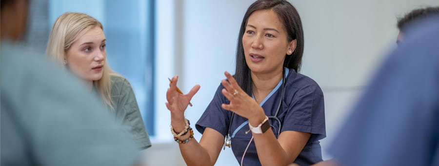 Group of hospital staff talking in conference room.