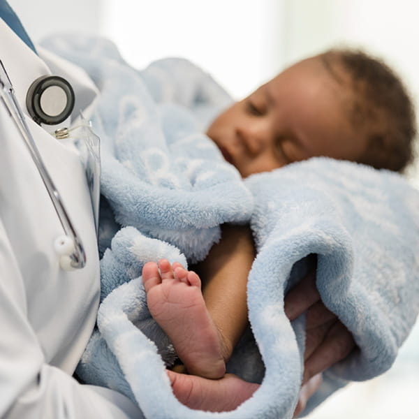 Doctor holding an infant in a blanket.